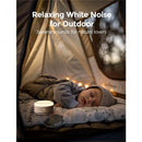 White noise machine beside a sleeping baby in a cozy tent, promoting relaxing outdoor sounds.