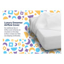 Luxury Dreamer Crib Mattress with an Airflow cover for enhanced air circulation, set against a colorful patterned background.