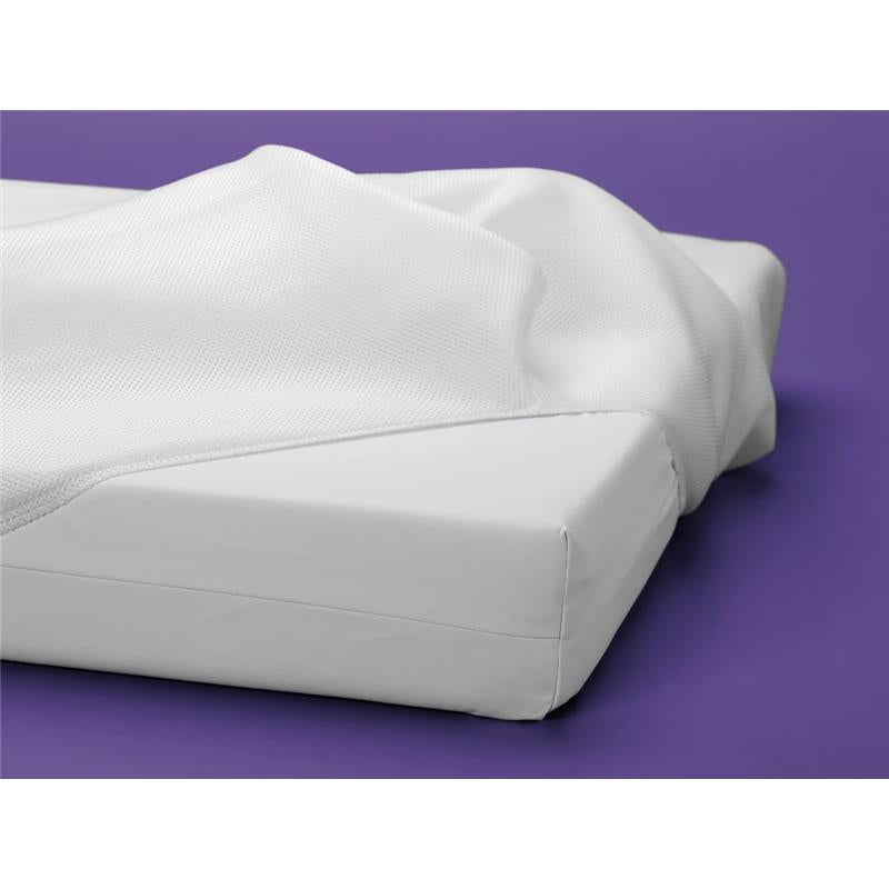 Luxury Dreamer crib mattress featuring a white, textured cover on a solid white base, set against a purple background.