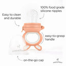 Soothing silicone baby food teething toy in light pink with a clear silicone nipple, easy-to-grasp handle, and on-the-go cap.