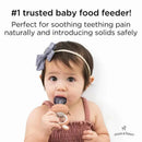 Soothing silicone baby food teething toy held by an infant, designed for easing teething pain and introducing solids.