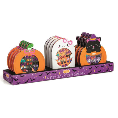 Mud Pie Halloween Glitzy Gems Ghost Sticker Earrings displayed on a vibrant purple shelf featuring Halloween motifs.