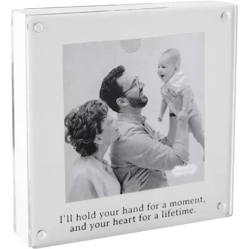 Baby handprint frame featuring a black and white photo of a smiling baby held by a man and woman, with an engraved quote.