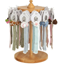 Crocheted pacifier straps in various colors and designs displayed on a wooden stand, ideal for keeping pacifiers close.
