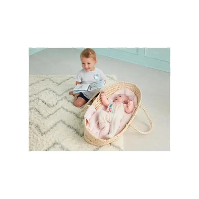 Child reading a book beside a baby girl in a woven bassinet, showcasing the Mud Pie Big Brother Book & Pin Set.