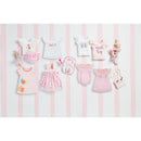 Assorted birthday-themed girl clothing including shirts, dresses, and accessories in pink tones with playful graphics.
