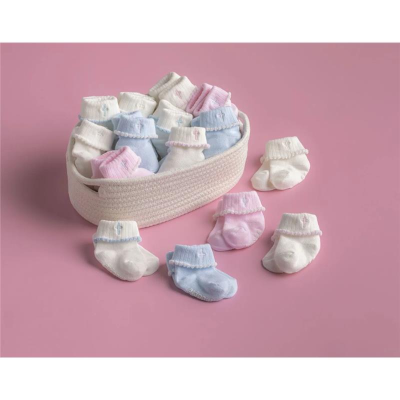 Pink and white cross foldover socks for infants, arranged in a woven basket on a pink background.