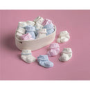 Pink and white cross foldover socks for infants, arranged in a woven basket on a pink background.