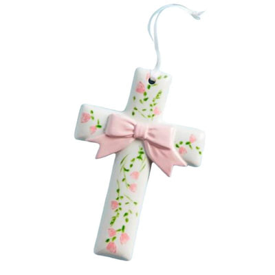 Ceramic cross ornament decorated with pink flowers and a pink bow, meant for display or gifting.