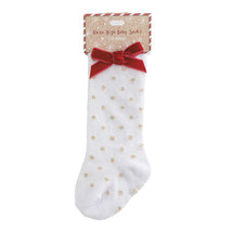 Knee-high baby socks for infants, featuring a white background with gold dots and a red bow at the top.