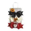 Set of three holiday hair bows: black, white with a turkey, and red with a Santa face, displayed on a decorative card.