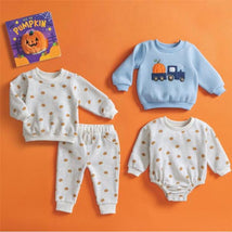 Pumpkin-themed baby clothing set including a blue sweatshirt with a truck design, a gray polka dot long-sleeve, and matching pants.