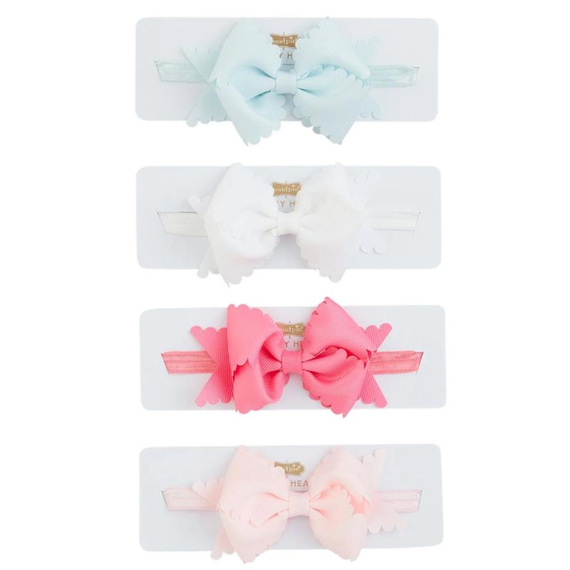 Light pink scallop bow headbands from Mud Pie, featuring four colorful bows on white display cards.
