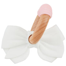 White silicone bow teething ring with a wooden handle and pink silicone tip, designed for infants to soothe teething discomfort.