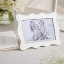 White enamel cross picture frame by Mud Pie, showcasing a black and white photo of three happy children.