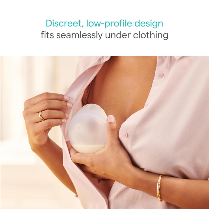 Silicone breastmilk collector cup held against the chest, demonstrating its discreet and low-profile design for under-clothing use.
