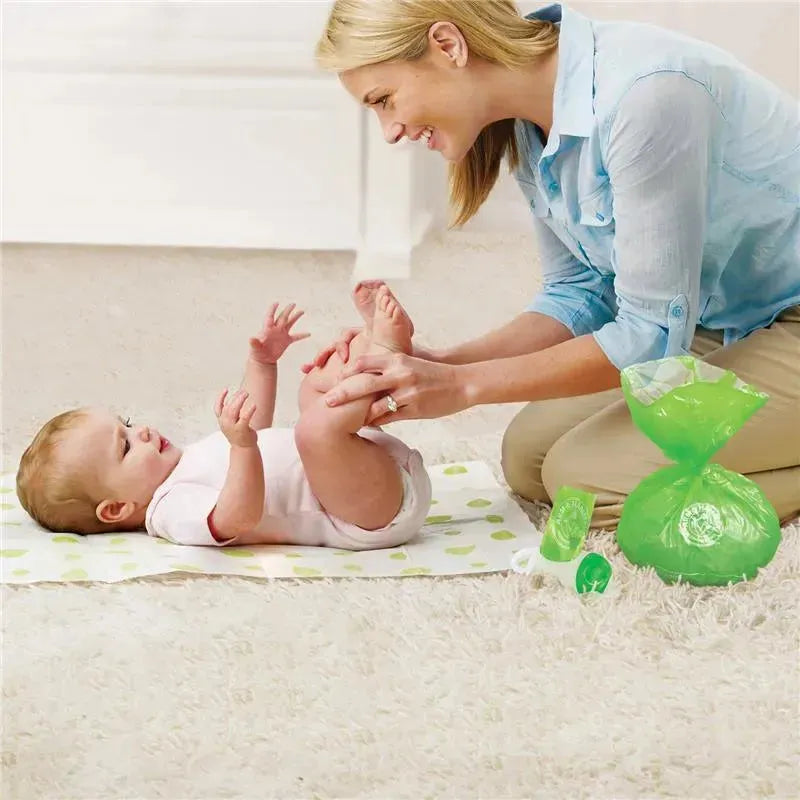 Mother with a baby on a changing mat, using Munchkin Arm and Hammer diaper disposal bags visible nearby.