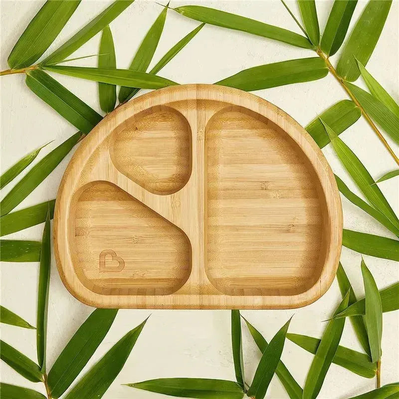 Bambou Divided Suction Plate by Munchkin, featuring three sections and a natural bamboo finish, surrounded by green bamboo leaves.
