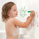 Child using Munchkin Bath Crayons to draw a smiling sun on a tiled shower wall, with playful scribbles present.