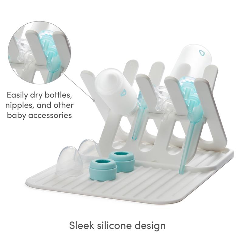 Munchkin bottle drying rack and mat in white, featuring a sleek silicone design with space for bottles and accessories.