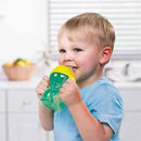 Toddler holding a Munchkin Click Lock Bite Proof Trainer Cup, 7 oz, with a green body and yellow lid, smiling happily.