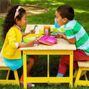 Children enjoying lunch with Munchkin Lunch Bento Boxes in vibrant colors, accompanied by stainless steel utensils and a drink.