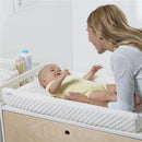 Munchkin Secure Grip Changing Pad in use, featuring a smiling baby in a yellow outfit interacting with a caregiver.