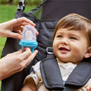 Silicone baby food feeder held by an adult, with a smiling baby in a high chair, enjoying the feeding process.