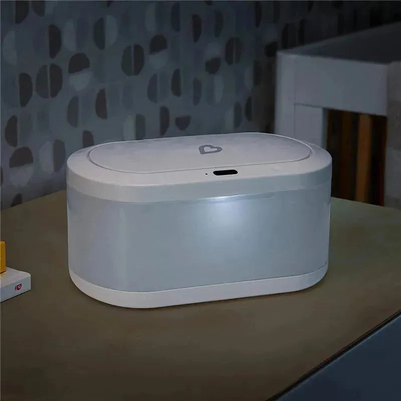 Touchfree Wipe Warmer by Munchkin, featuring a sleek design with a heart-shaped lid and interior light, on a tabletop.