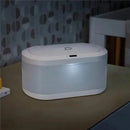 Touchfree Wipe Warmer by Munchkin, featuring a sleek design with a heart-shaped lid and interior light, on a tabletop.