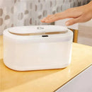 Touch-free wipe warmer by Munchkin, featuring a hand sensing area, placed on a wooden surface.
