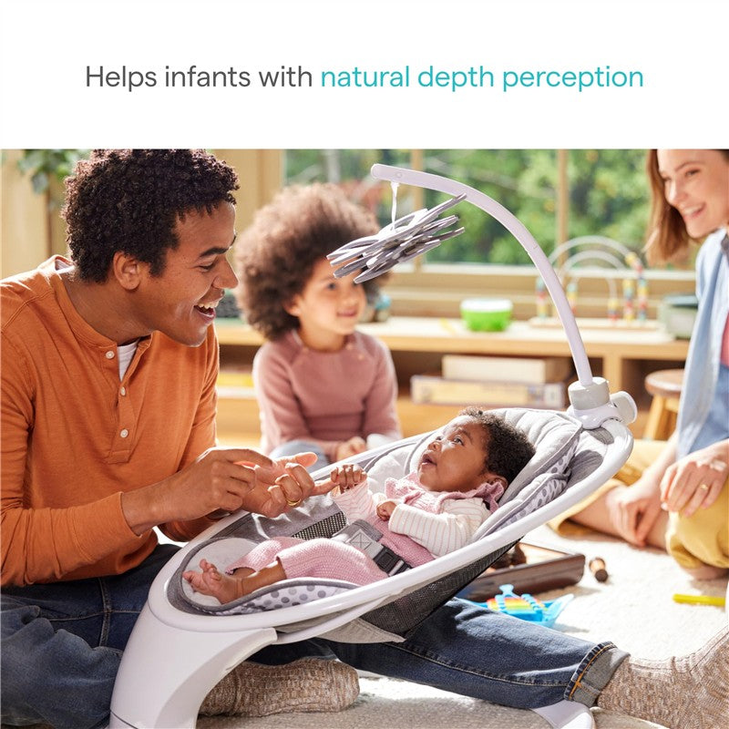 High-contrast Munchkin Baby Bloom mobile with a mirror, being enjoyed by a father and his infant in a cozy setting.