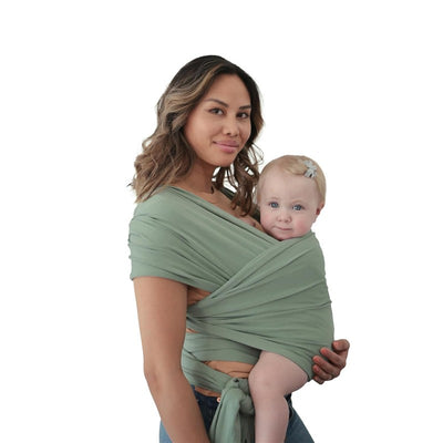 Organic cotton baby wrap carrier in Roman Green worn by a woman, securely holding a baby against her chest.