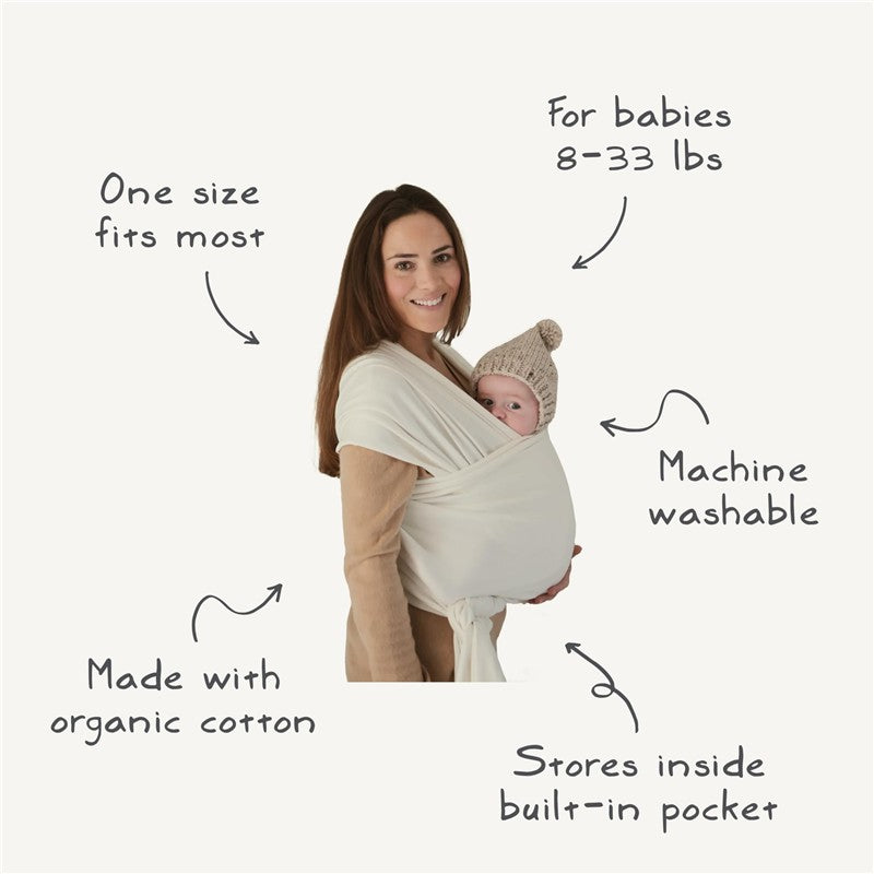 Mushie 100% Organic Cotton Baby Wrap Carrier in blush, supporting a baby, with labels detailing features.
