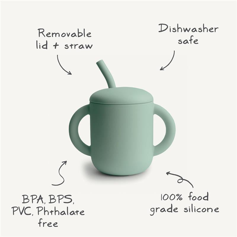 Mushie silicone training cup with removable lid and straw, featuring green color and notes on safety and care.