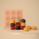 Mushie Baby Food Freezer Tray in blush color with colorful frozen baby food cubes stacked in front.