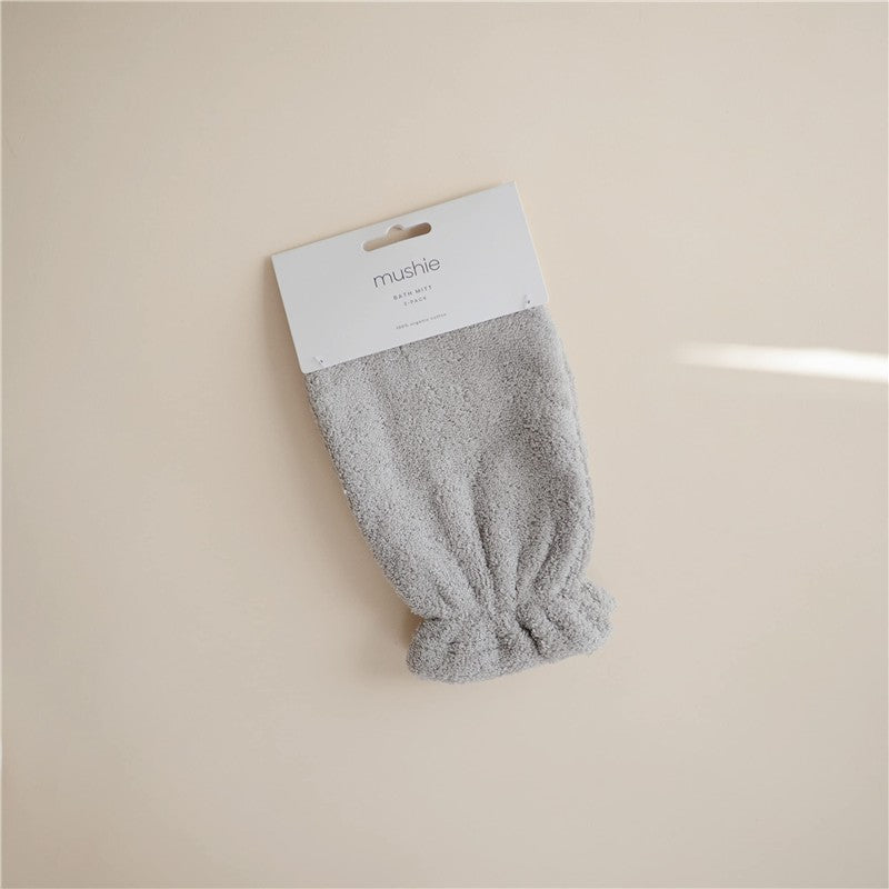 Gray organic cotton bath mitt from Mushie, featuring a textured surface and elasticized opening for easy use.
