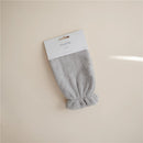 Gray organic cotton bath mitt from Mushie, featuring a textured surface and elasticized opening for easy use.
