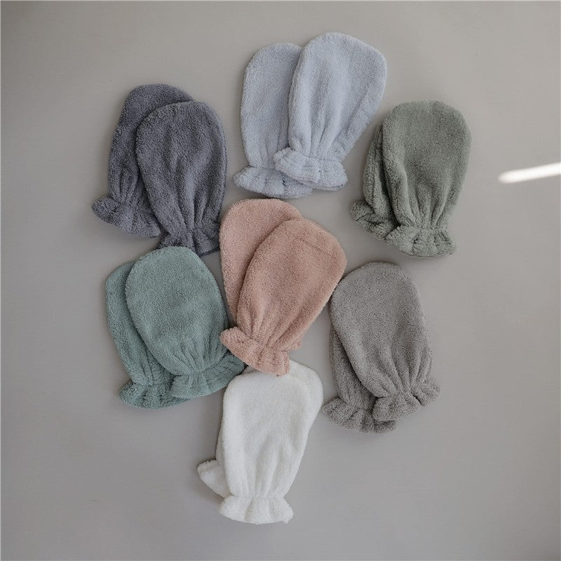 Organic cotton bath mitts in gray, pink, green, and blue colors, arranged neatly, showcasing their soft texture.