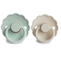 Two Frigg Daisy natural rubber baby pacifiers in seafoam green and cream, designed for ages 6-18 months.