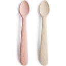 Silicone feeding spoons in blush and shifting sand colors, designed for feeding babies, with soft, rounded edges.