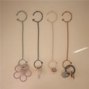 Adjustable silicone straps in blush and shifting sand colors, featuring playful designs like flowers and toys.