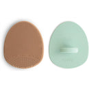 Silicone baby bath cradle cap brush set in natural and Cambridge blue, featuring textured surfaces for gentle cleaning.