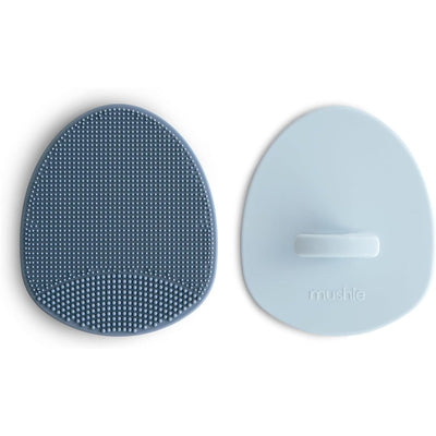 Silicone baby bath cradle cap brush set in Tradewinds and Periwinkle colors with textured and smooth surfaces.