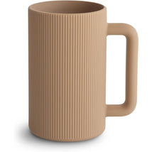 Mushie Bath Rinse Cup in a natural beige color, featuring a ribbed design and a sturdy handle.