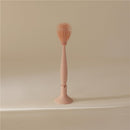 Mushie silicone baby bottle brush in blush color, featuring a sleek handle and a textured brush head for effective cleaning.