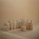 Mushie baby cream and skincare products in various containers, showcasing lotions and creams in soft packaging on a light background.