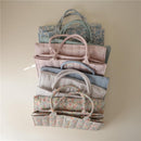 Organized stack of Mushie Baby Diaper Caddies in various pastel colors, showcasing the blush option at the front.