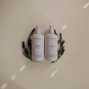 Mushie baby body lotion and shampoo & body wash in lavender, surrounded by lavender sprigs on a light background.
