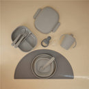 Mushie Bento Lunch Box set in cloud color, featuring a divided lunch container, utensils, and a sippy cup on a placemat.